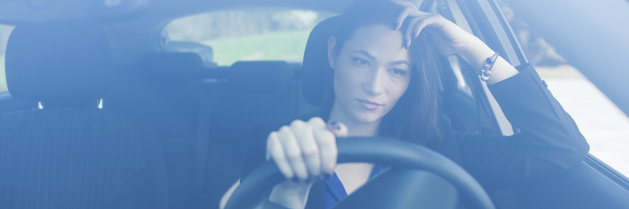 woman driving her car and looking concerned