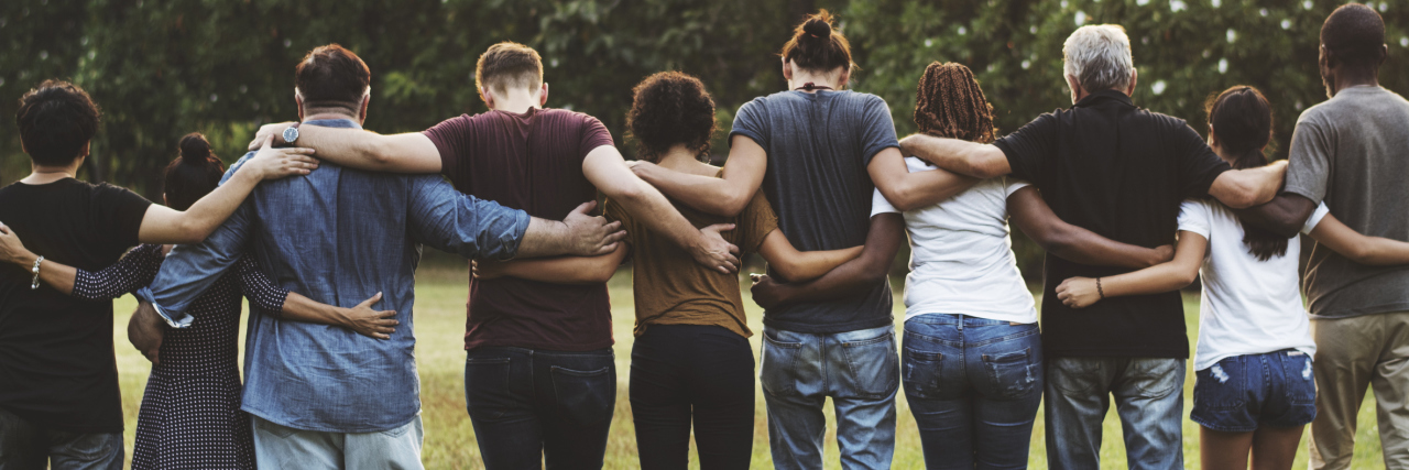 group of friends walking in a line with their arms around each others' shoulders