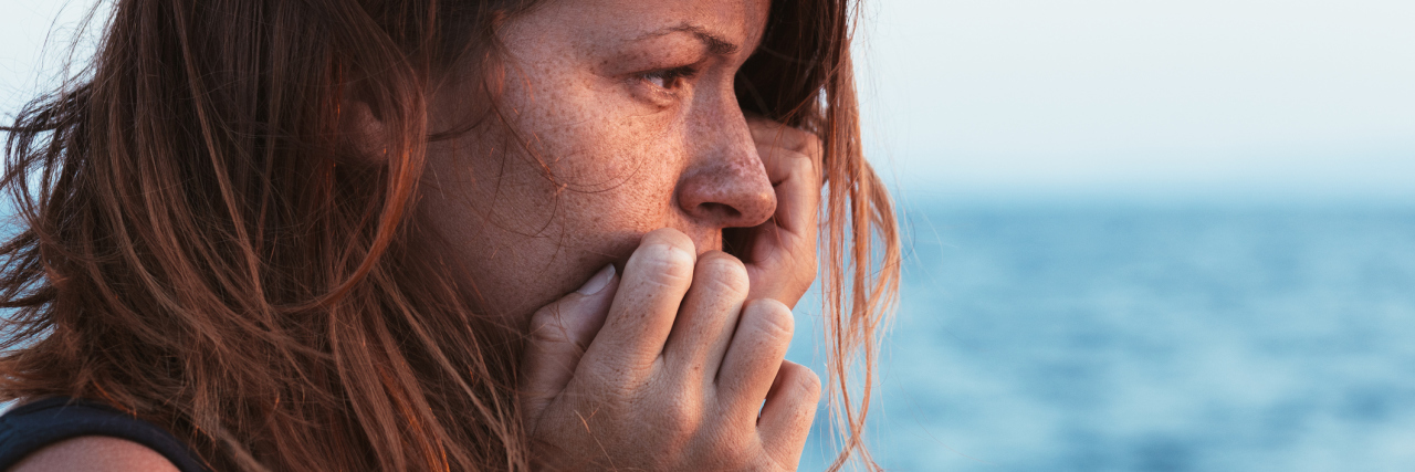 young woman teary alone by sea