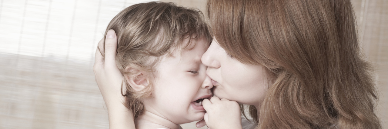 I Can't Make My Daughter Feel Better, but This Is What I Can Do A mother holding her crying toddler.