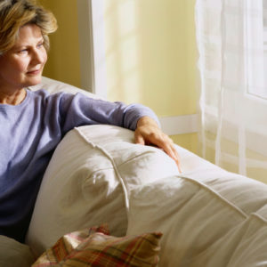 woman sitting on her couch and looking out the window