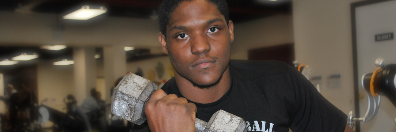 How to Exercise in a Wheelchair Main in a wheelchair lifting a weight