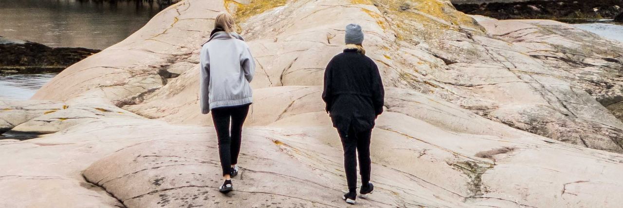 5 Ways You Can Support a Friend Struggling With Depression two people walk together on rocks