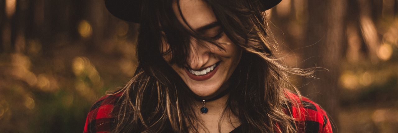When an Improvement in Your Mental Health Is Surprising young woman dark hair smiling in forest