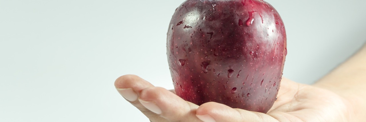 An Apple a Day: Breast Cancer, Research, and Being Proactive hand holding apple