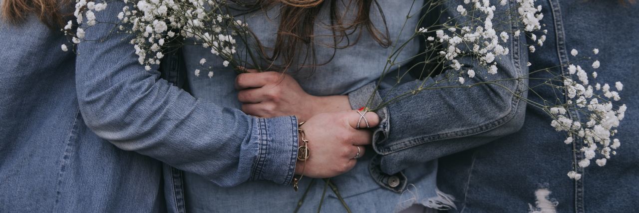 How My Friends Affect How I See My Bipolar Disorder back view of female friends close to each other and holding flowers