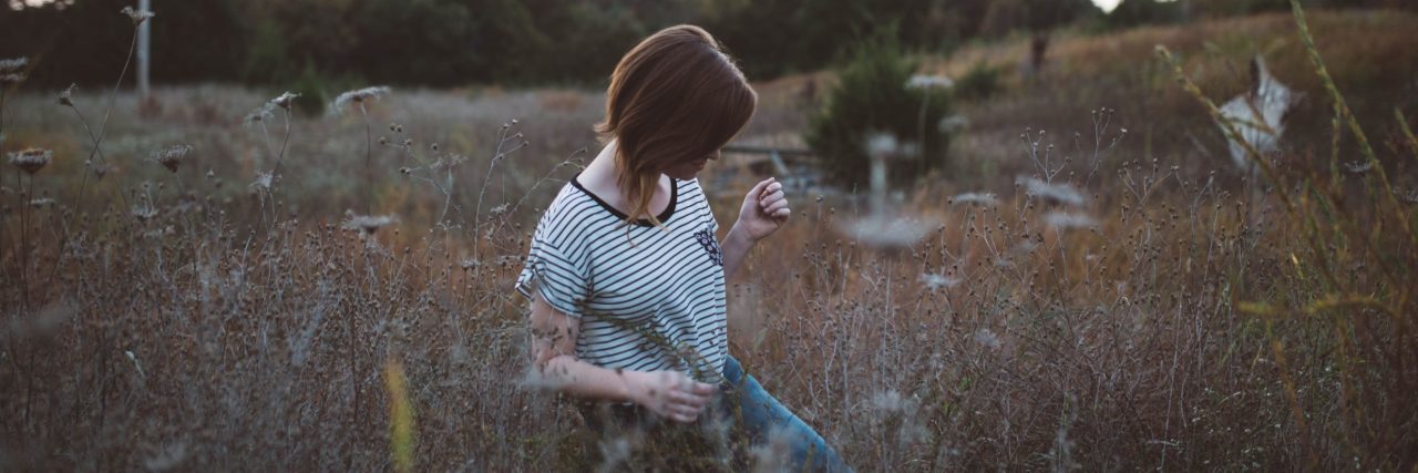 woman standing in field looking away from camera