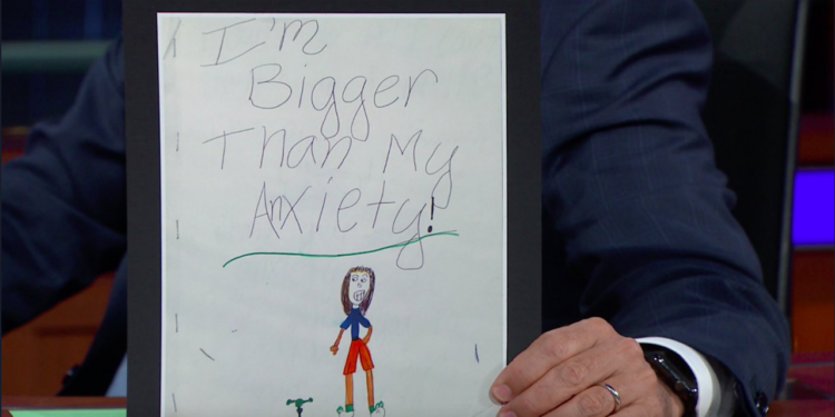 Stephen Colbert holds Emma Stone's drawing of anxiety monster