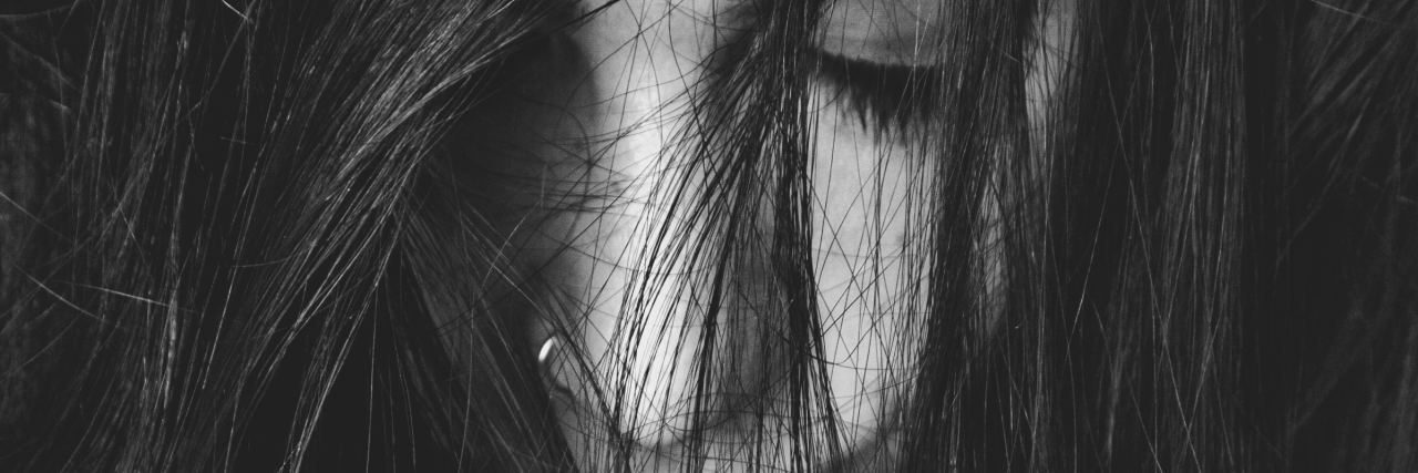 To My Suicidal Self Who Needs a Reminder to Stay woman with dark hair covering most of her face looking down