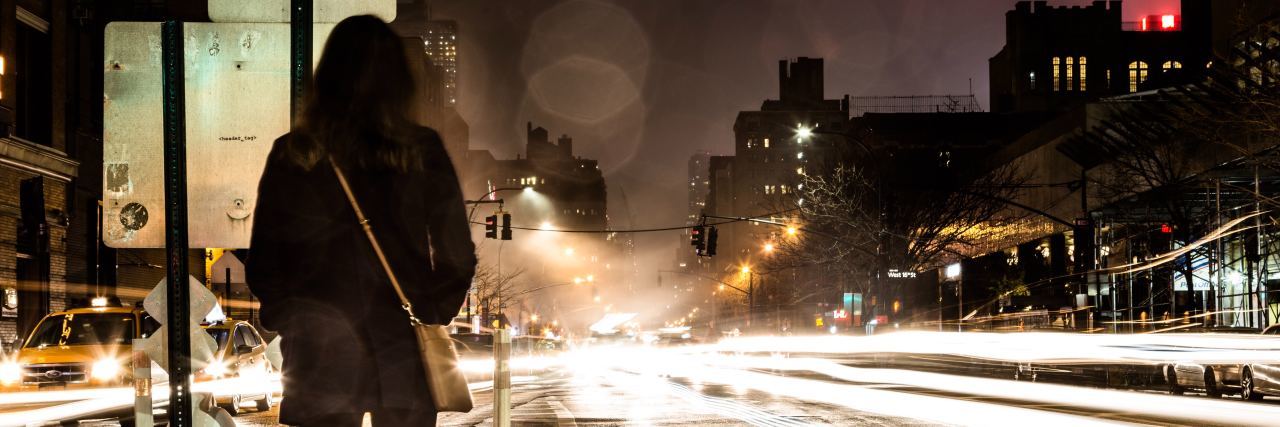 When Bipolar Makes You Fear ‘Good' Days A woman stands on the side of a street at night with traffic lights all around her
