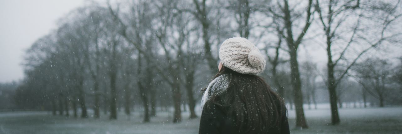 When I Realized My Depression Was Seasonal Affective Disorder a woman stands outside in the winter