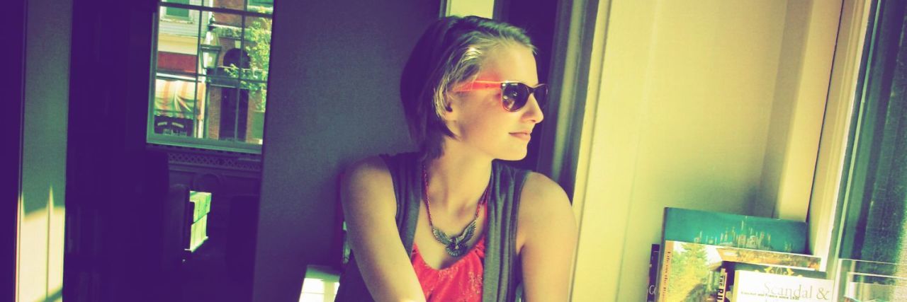 Struggling to Find Doctors Who Are Educated on Endometriosis woman wearing sunglasses and looking out a window