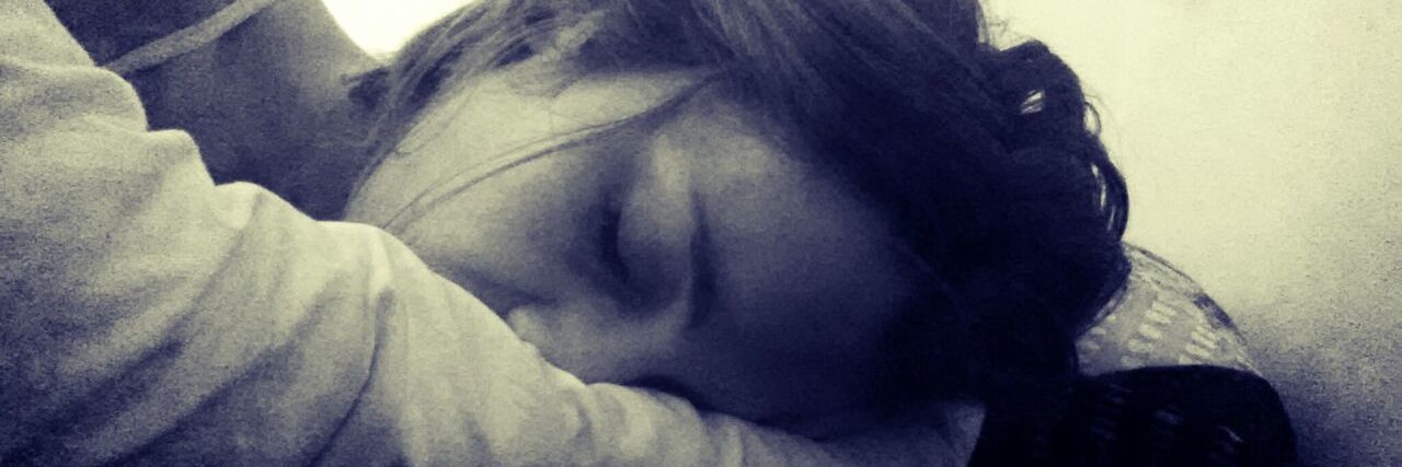 Depression and Suicidal Ideations Are the Monsters Inside My Head a woman lays on a bed with her head in her hands