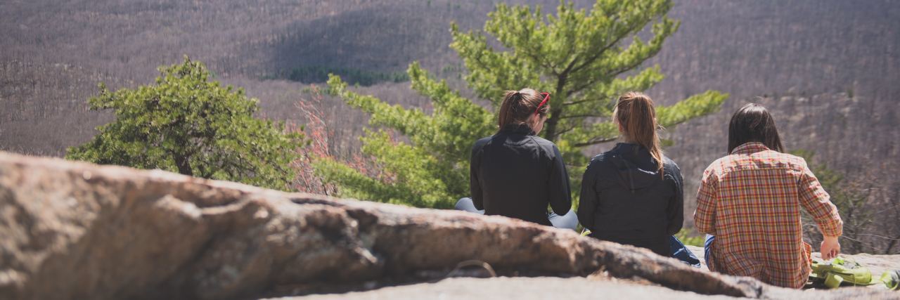 When Friendship in Eating Disorder Treatment Helpful or Harmful three girls sit on rocks overlooking hills