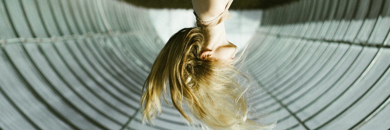 a woman is upside down with her hair flipping