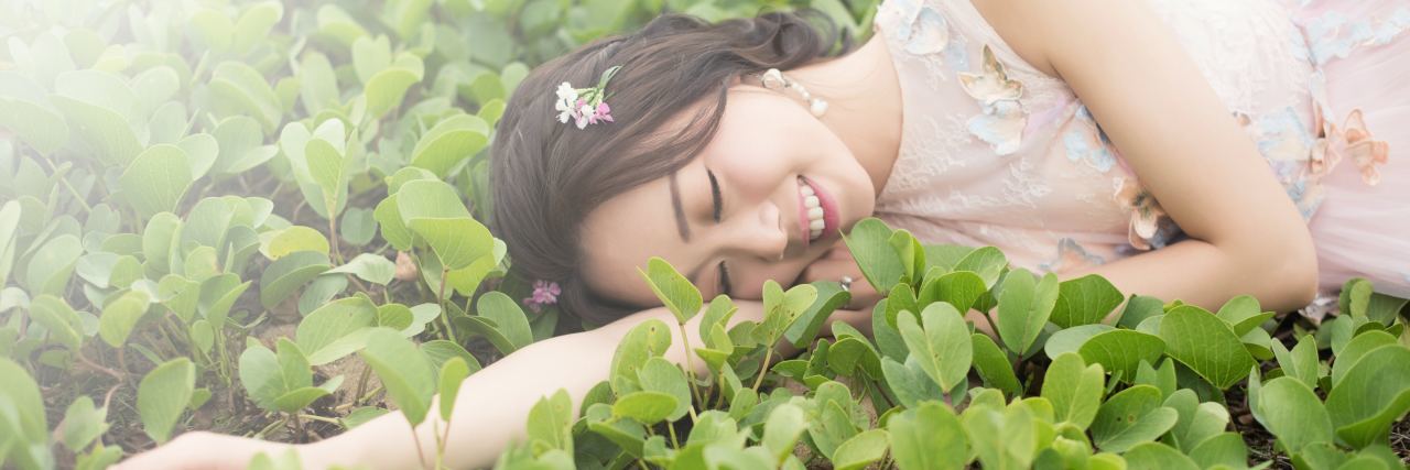 young asian woman lying in flowers or vegetables happy smiling