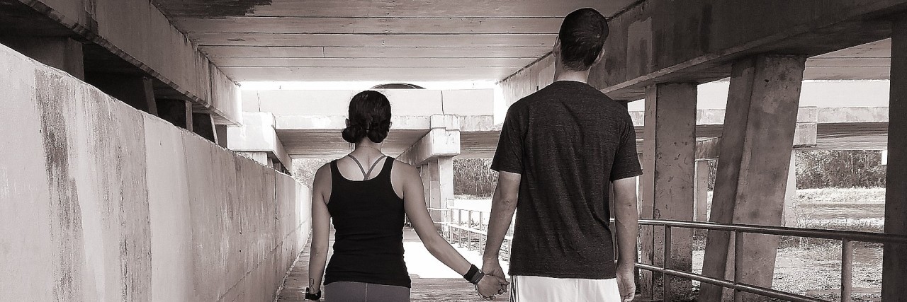 man and woman walking together and holding hands