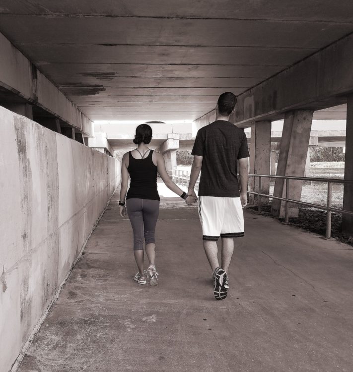 man and woman walking together and holding hands