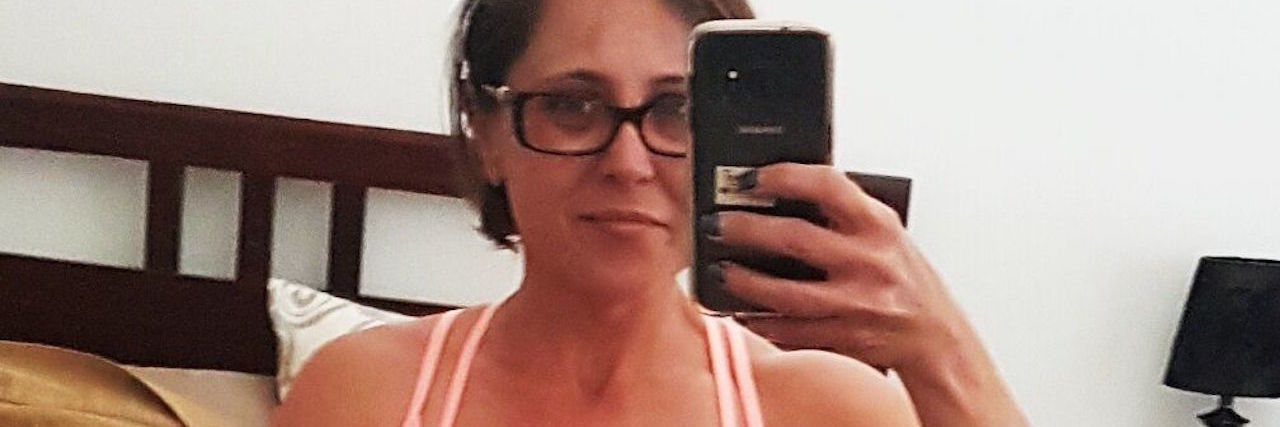 I Am Proud of My Body Despite Having Cystic Fibrosis woman taking a photo of herself after working out