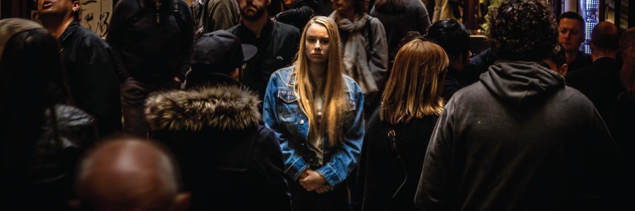 woman stands in the middle of a crowd