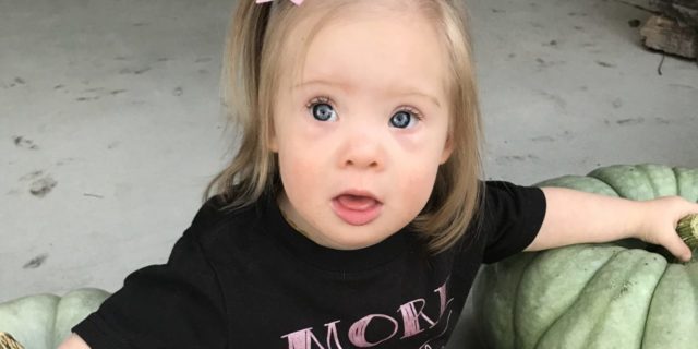 The Unprofessional Way a Technician Delivered My Unborn Child's Down Syndrome Diagnosis Little girl with Down syndrome sitting amongst pumpkins.