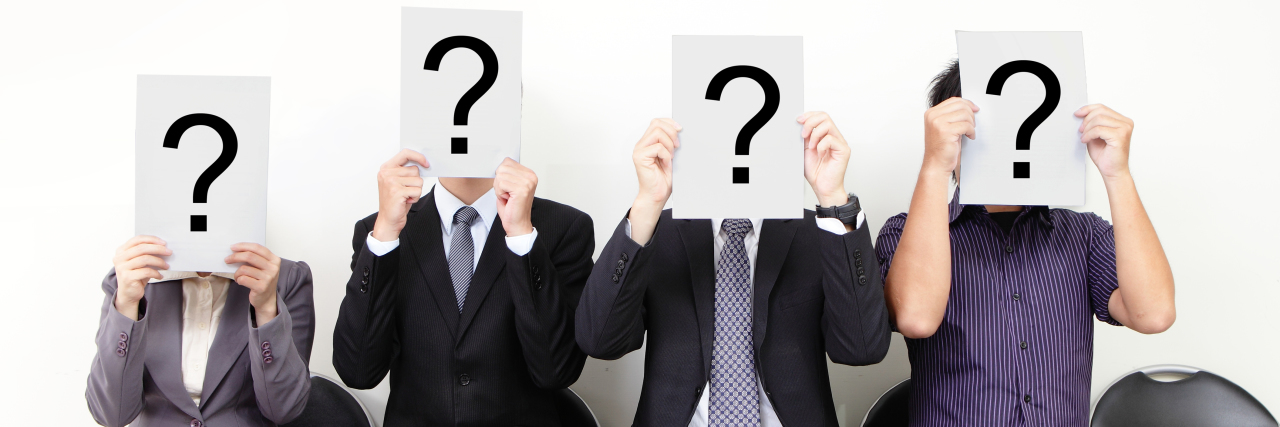 Deciding Whether to Disclose Epilepsy at a Job Interview People holding white billboards with question marks on it and waiting for job interview.