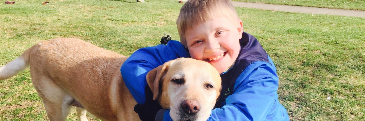 My Son With Down Syndrome Has a Cheering Section Boy with Down syndrome hugging his brown dog