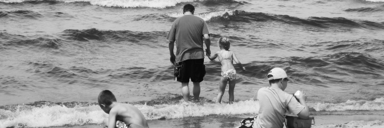 What It's Like Being Married to a CHD Warrior A father with his three children at the beach.