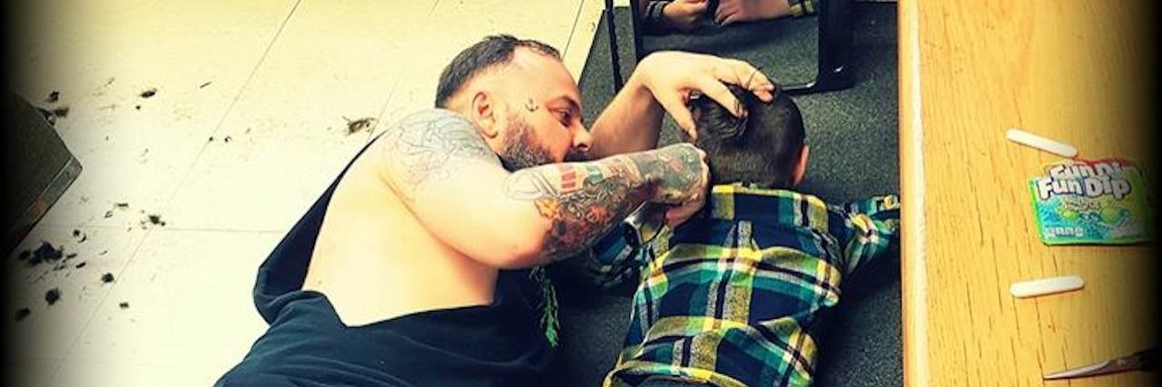 Viral photo of barber Jakob on the floor cutting Wyatt Lafreniere's hair. Wyatt is on the autism spectrum.