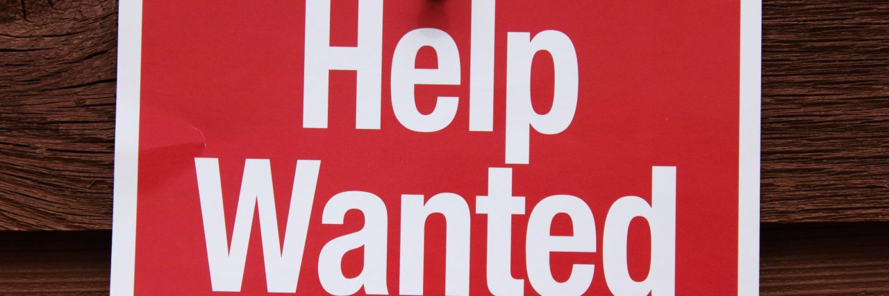 How to Help Autistic People Find Jobs Help Wanted Sign on a wood background.