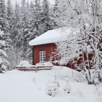 Charming red house with snow on the roof in winter.