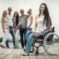 Young woman in wheelchair with friends on a pier.