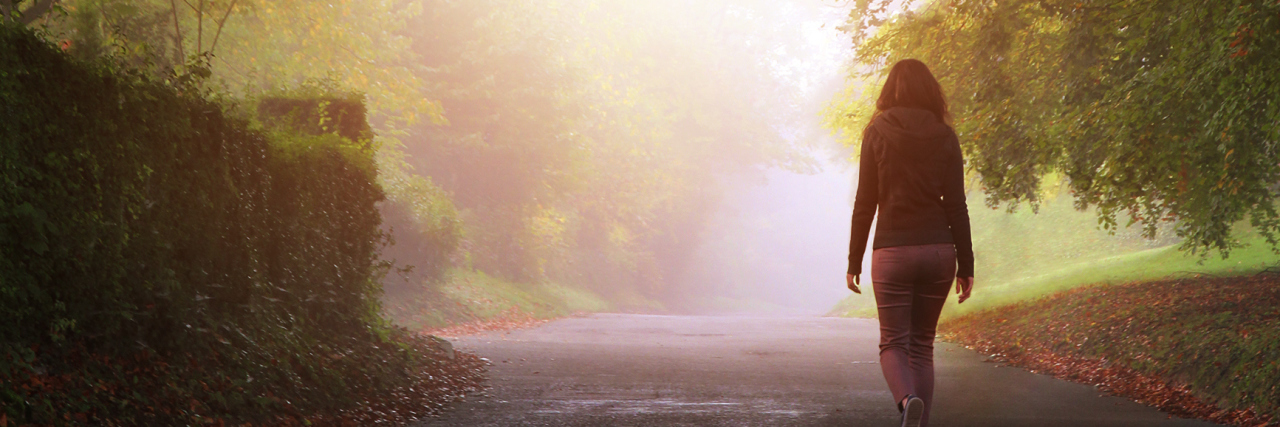 Adults Have Autism Too A solitary woman walking on a country road.