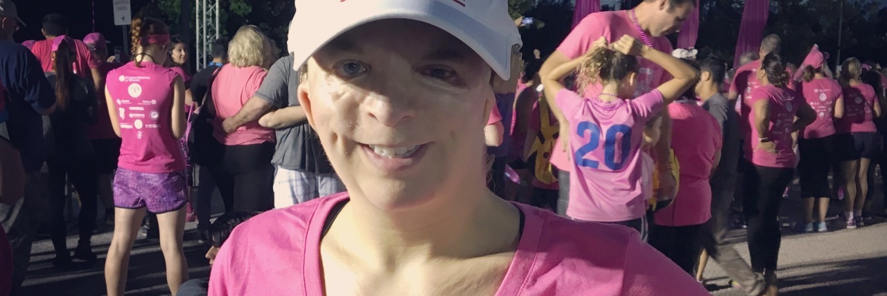 woman at a race wearing a pink shirt that says 'be brave, be strong, be fearless'