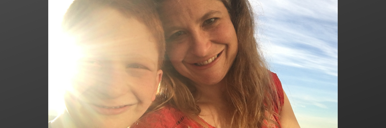 Autism Diagnosis at 13 Years Old Mother and son smiling at camera with sun shining bright on them