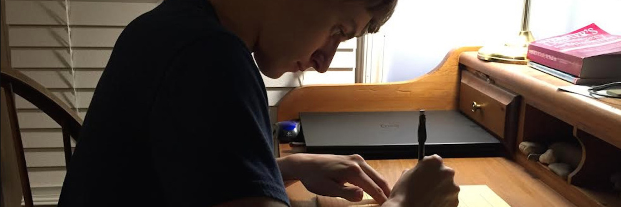 The author's son, working on homework at his desk