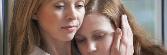mother comforting sad daughter through struggle