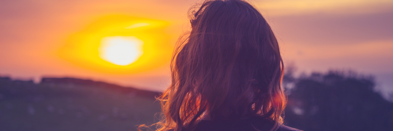Reassessing My Life After Being Diagnosed With Cancer Twice Young woman admiring the sunset over fields