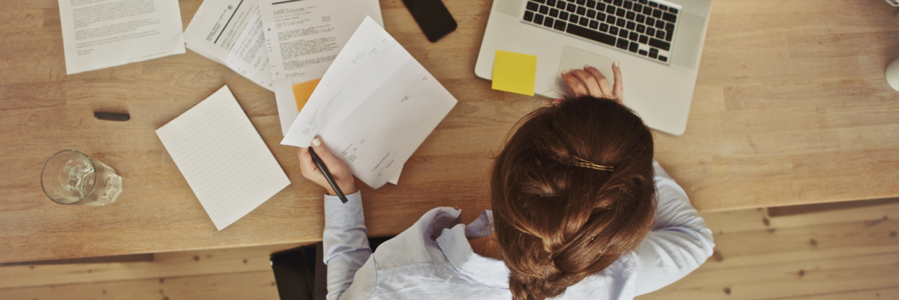 Finding Your Dream Job With Chronic Illness, ME/CFS woman working at her desk on a laptop