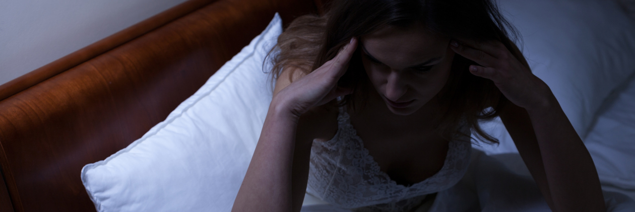 Not Sleeping Due to Insomnia, Restless Leg Syndrome, Anxiety, OCD women sitting up in bed unable to sleep