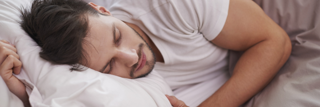 Finding the Right Pillows for Chronic Back Pain man resting and holding a pillow