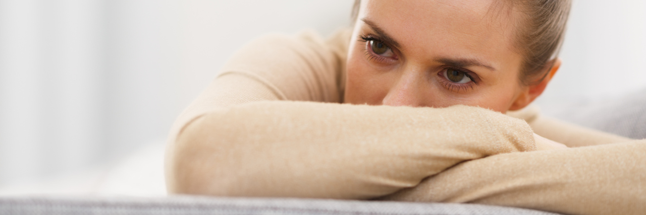 woman crossing her arms and leaning on a couch