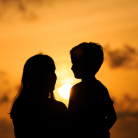 happy loving mother and little son at sunset