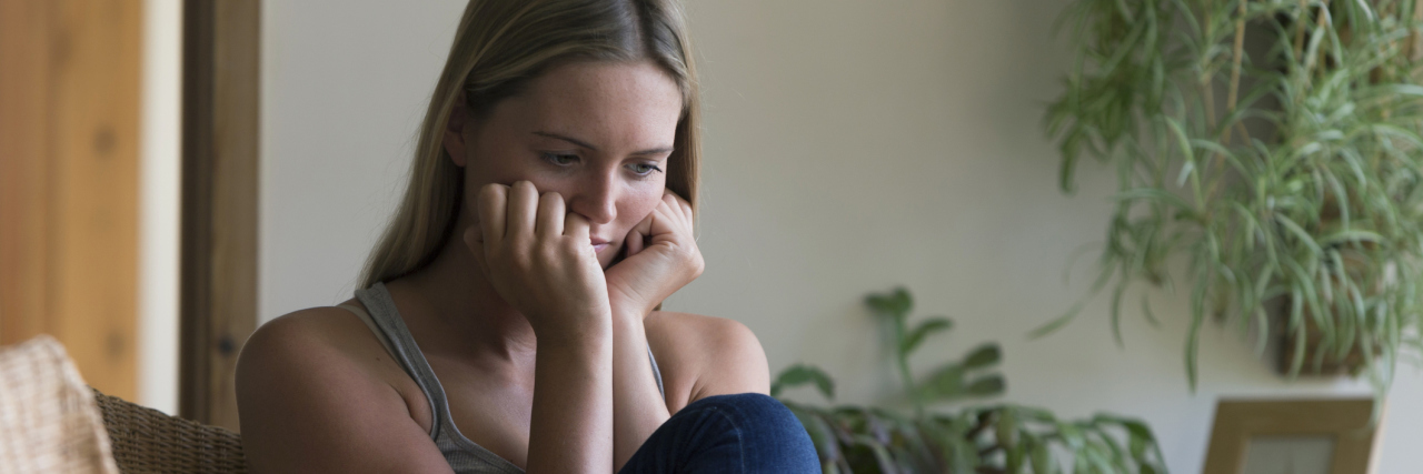 When You Feel Guilty About Being Depressed woman sitting at home looking upset with head in hands next to tablet