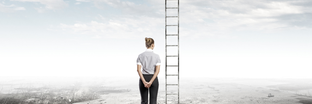 Rear view of businesswoman standing near ladder going high in sky