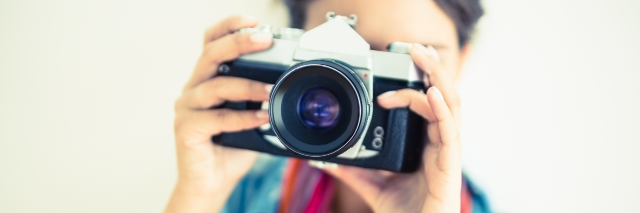 Documenting My Chronic Illness Journey Through Pictures woman taking a photo with a camera