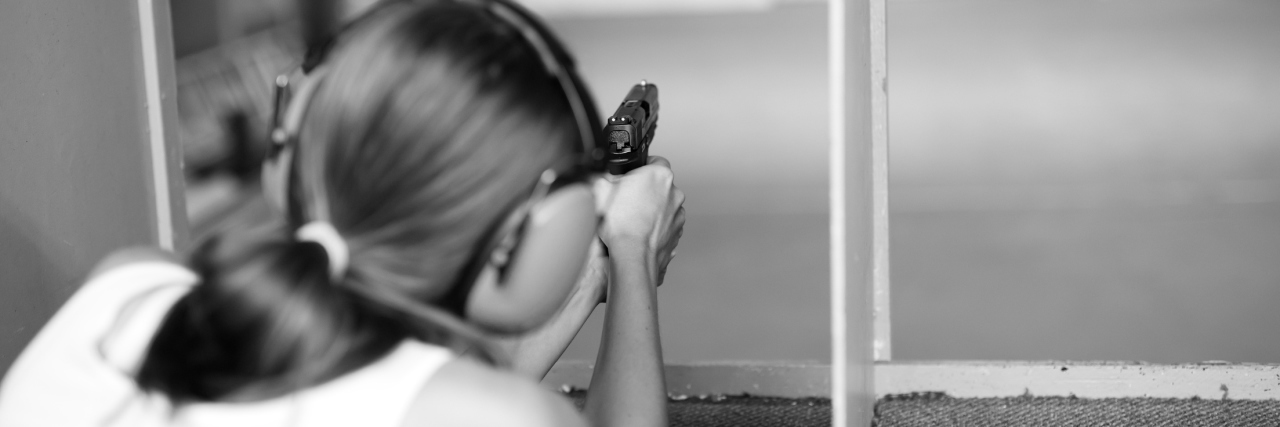 Gun Control and Mass Shootings: Mental Illness is a Separate Problem black and white photo of woman at gun range with handgun