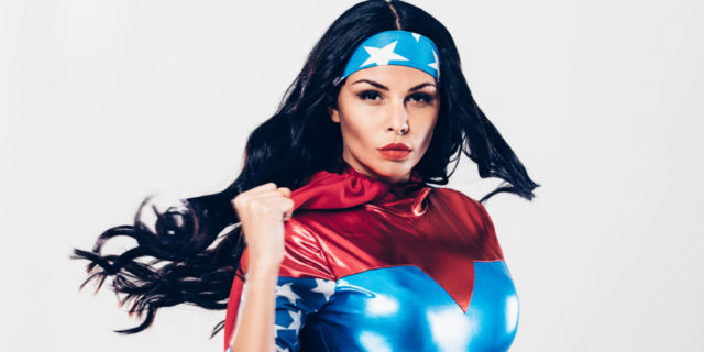 How I Relate to Superheroes Because of My MS A woman in a superhero costume, fist up in the air.