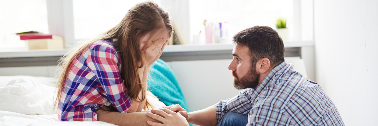 How Epilepsy Changed My Relationship With My Father Teenage girl crying while her father reassures her.