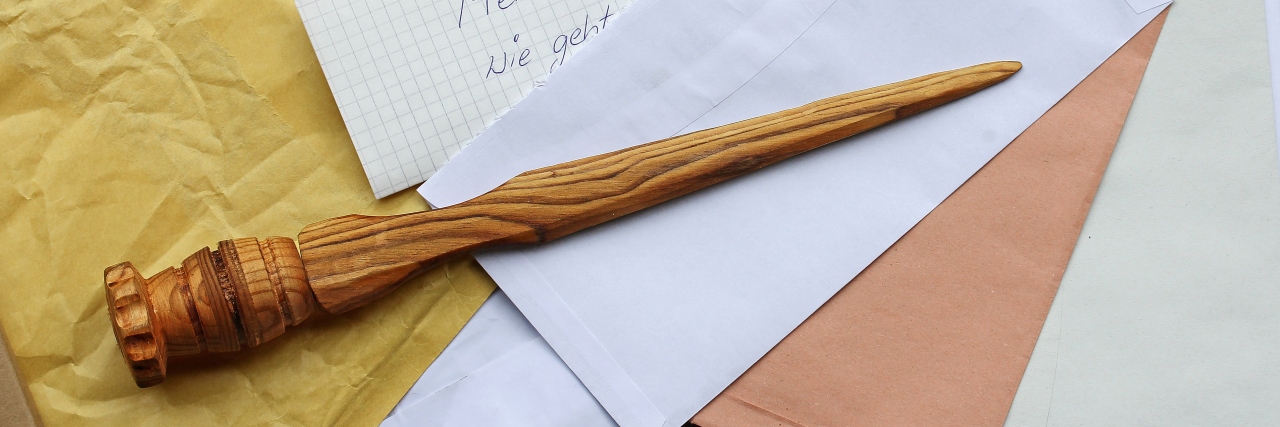 Fine Motor Coordination at Work With Cerebral Palsy A letter opener in wood and open mail.